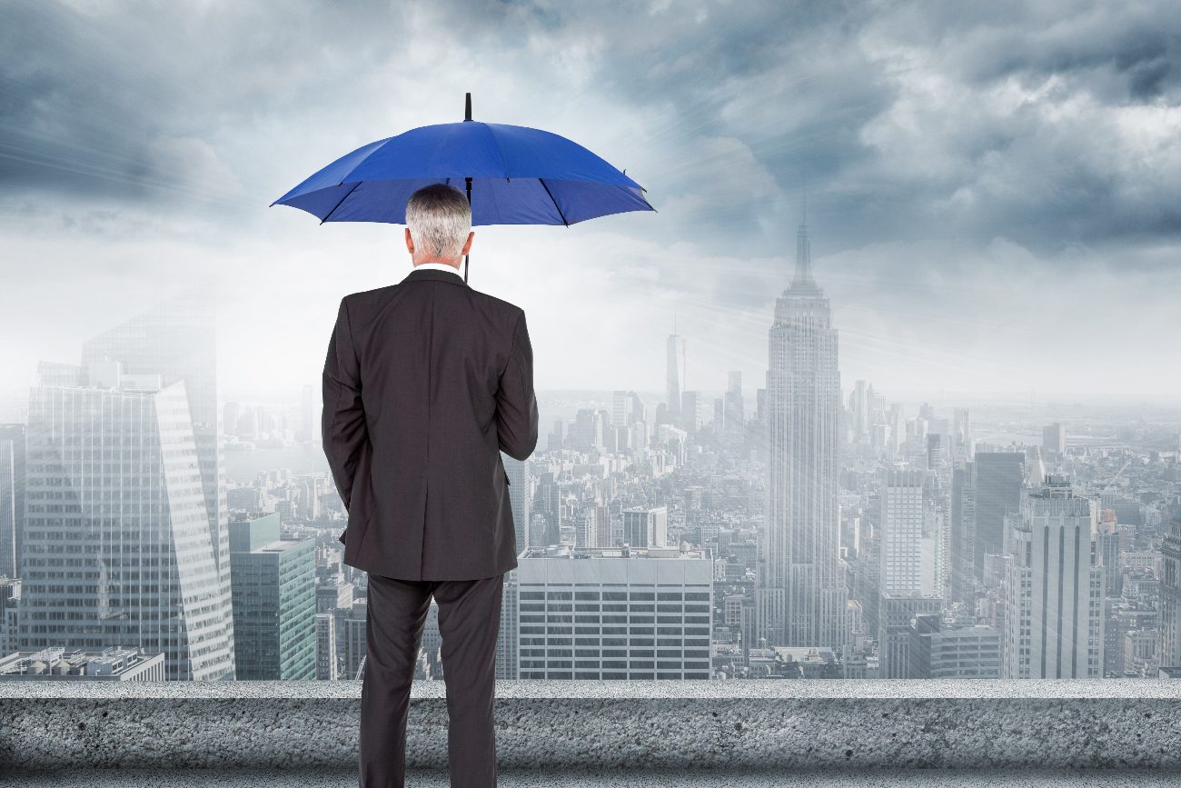 Businessman protected under an umbrella